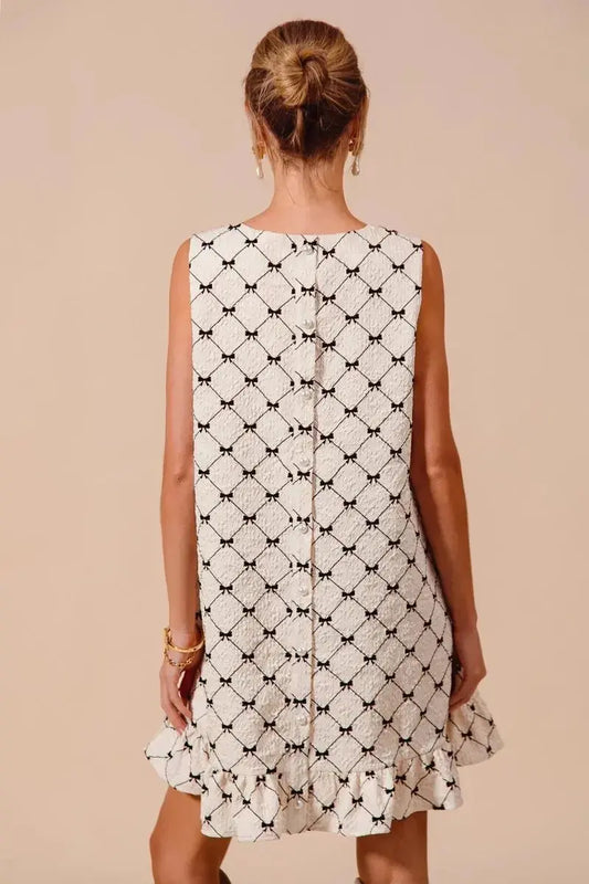 Back view of SO ME Texture Bow printed sleeveless mini dress with ruffle hem in black and white