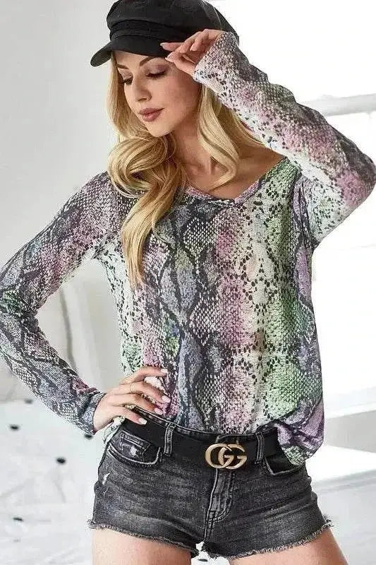 Woman wearing BiBi snakeskin print low gauge Hacci V-neck top with black shorts and hat