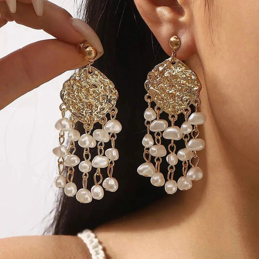 18K gold-plated dangle earrings with synthetic pearls on model's ear