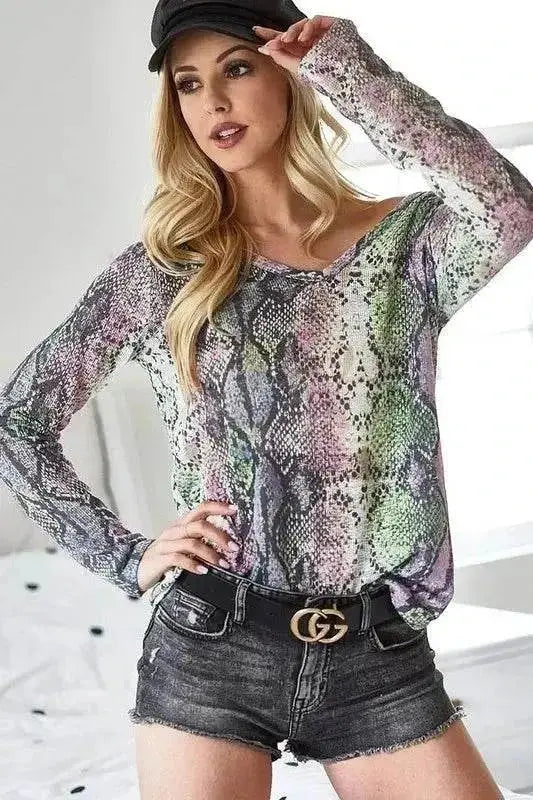 Woman wearing BiBi snakeskin print low gauge Hacci V neck top with denim shorts and black belt